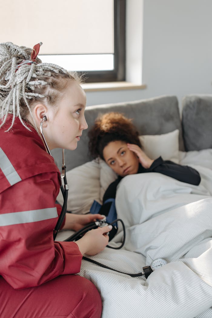 Paramedic attending to a patient experiencing illness symptoms at home. Indoors health care support.